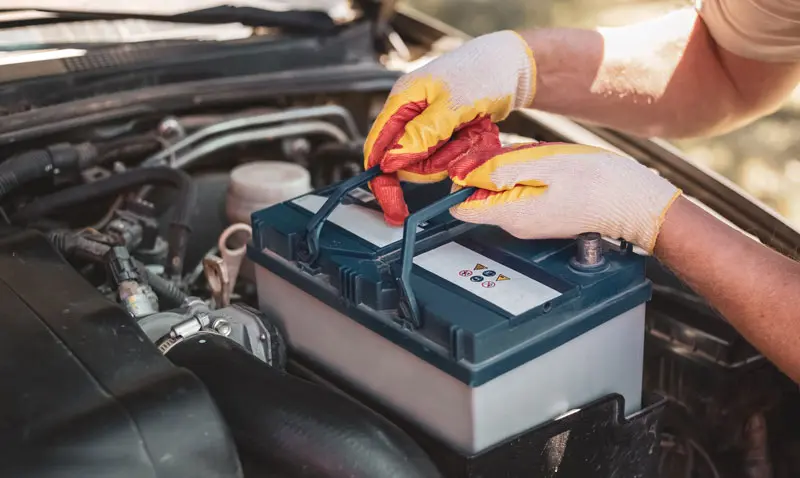 Battery-replacement Mechanic putting a new battery in a car