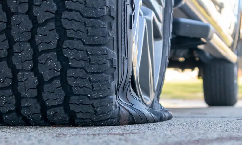 Flat-Tire-change close up view of a cars flat tire on the roadside